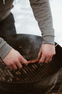 person barbecuing meat